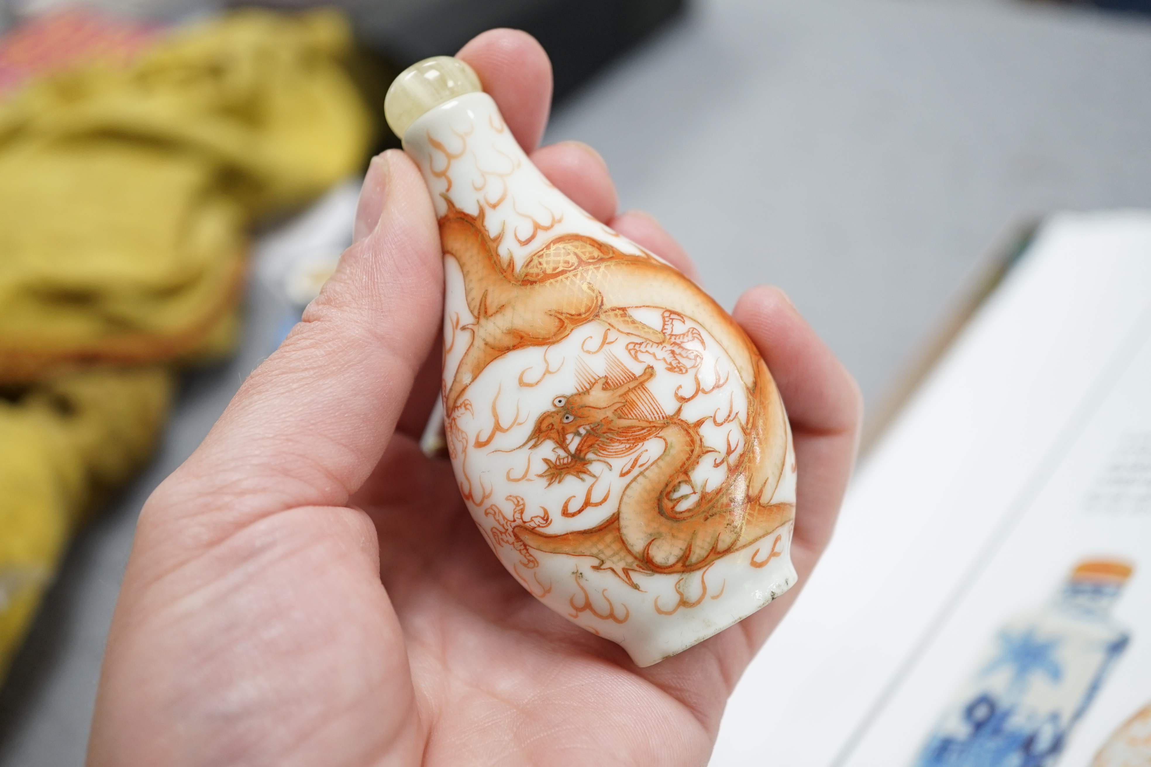 A Chinese iron red enamelled ‘dragon’ snuff bottle, Tongzhi mark and of the period (1862-74), together with two Chinese blue and white cylindrical snuff bottles, 19th century